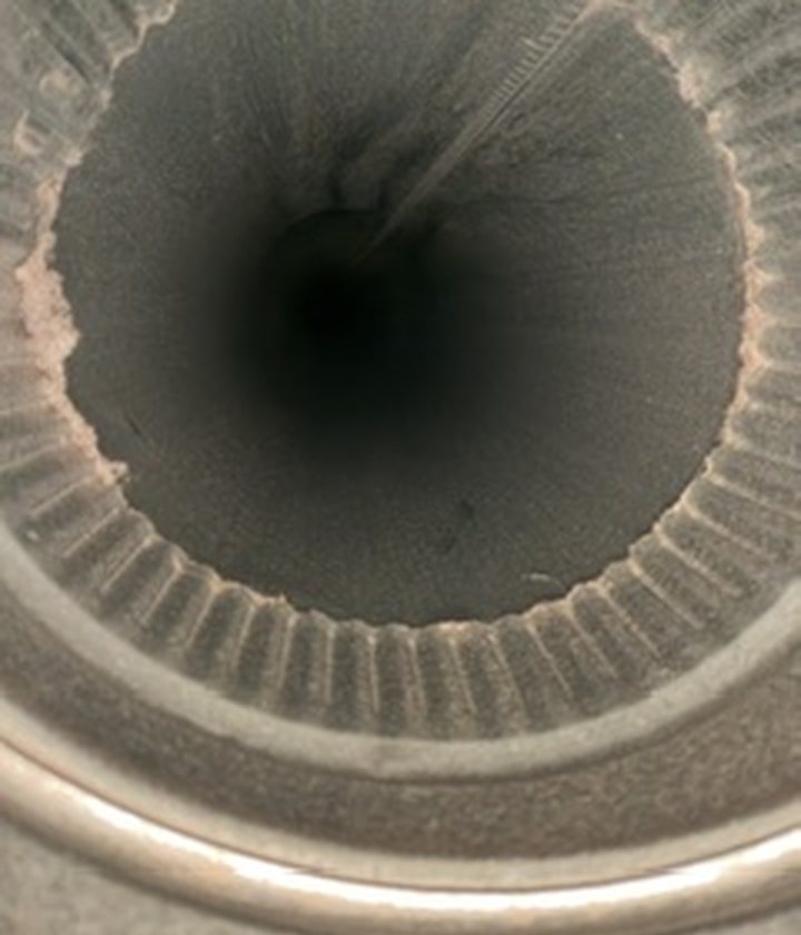 Looking down the same kind of duct after cleaning: clean metal, open all the way through